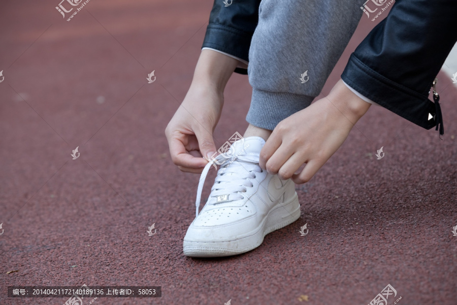 在跑道上系鞋带的人