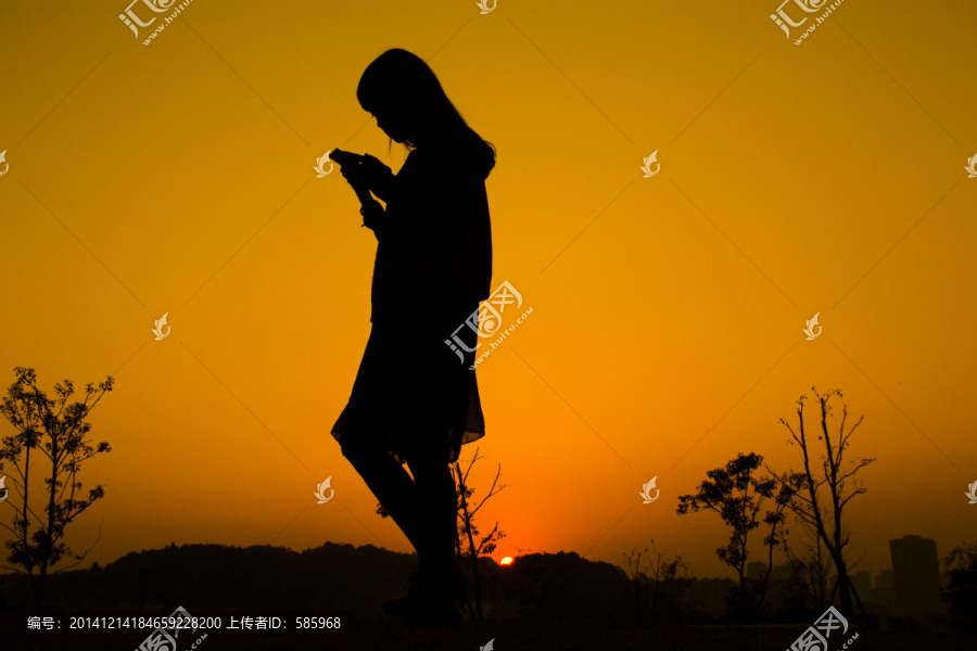 玩手机的美女夕阳剪影