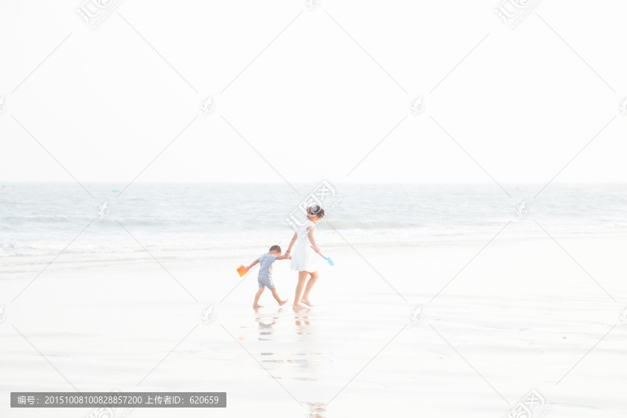 沙滩上牵手跑动的母子
