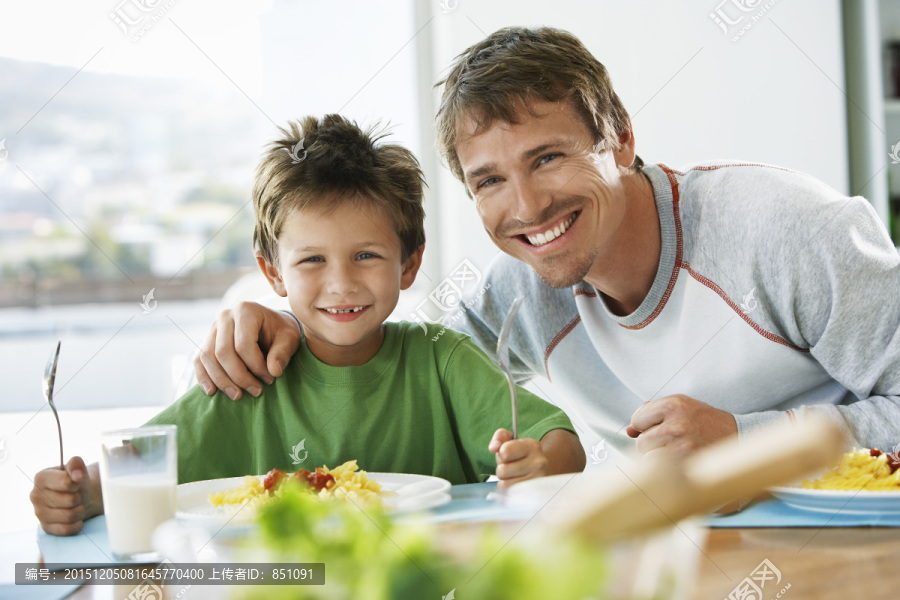 爸爸和儿子坐在餐桌边