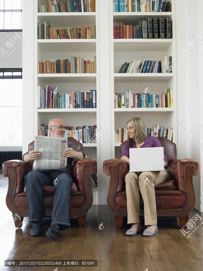 夫妇坐在扶手椅的人阅读