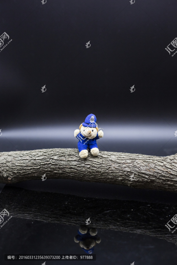 坐在木头上的小熊玩偶