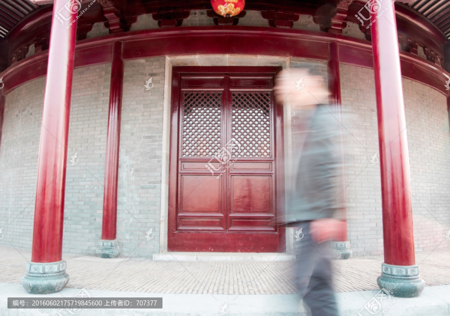 游客在中国仿古建筑大门前经过