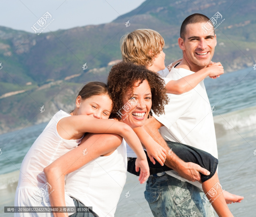 沙滩上孩子骑在父母背上