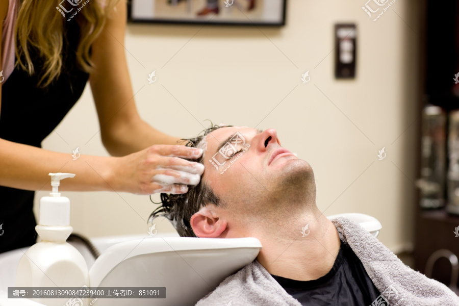 在美发沙龙洗头发的男客户