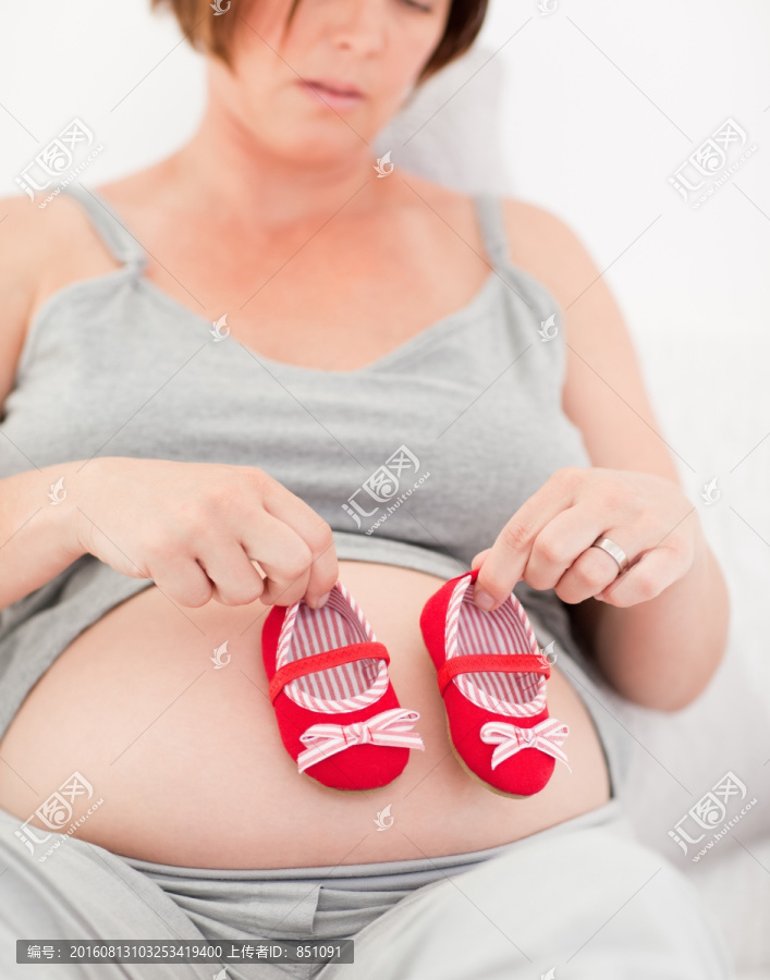 拿着婴儿鞋的孕妇