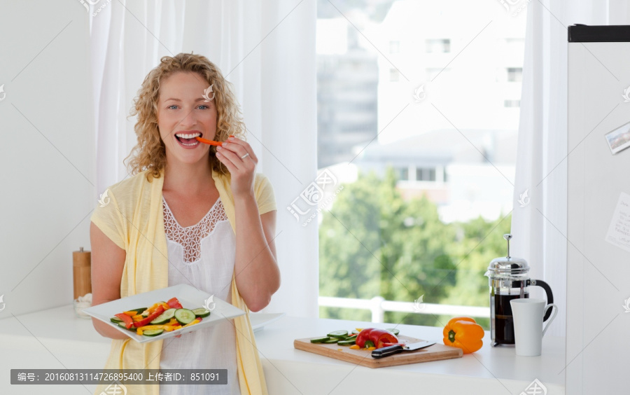 美丽的女人在家吃蔬菜