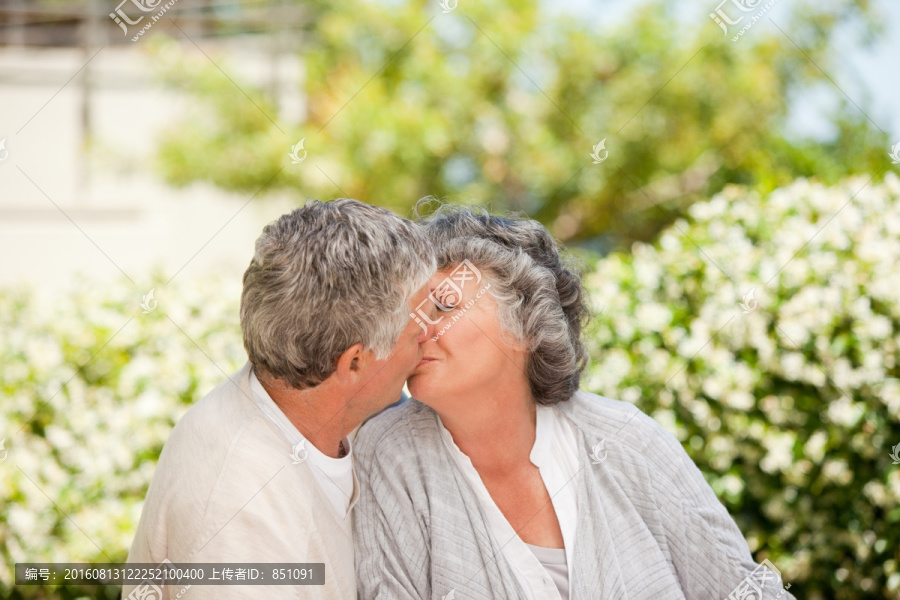 男人在花园里吻他的妻子