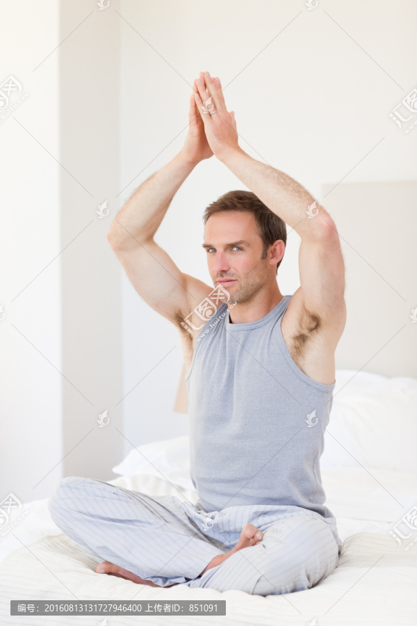 男子在床上练习瑜伽