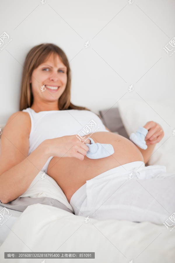 在床上玩小袜子的孕妇