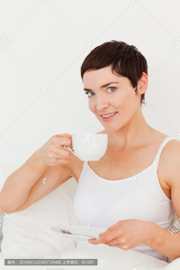 在床上喝咖啡的美丽女人