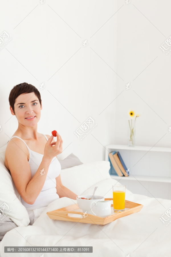 在床上吃早餐的女人