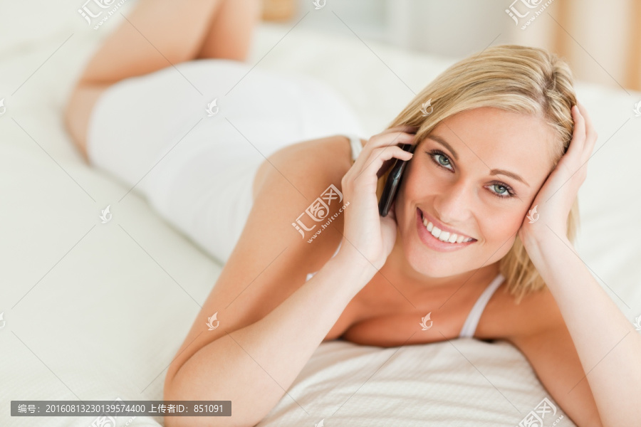 在床上打电话的居家女性