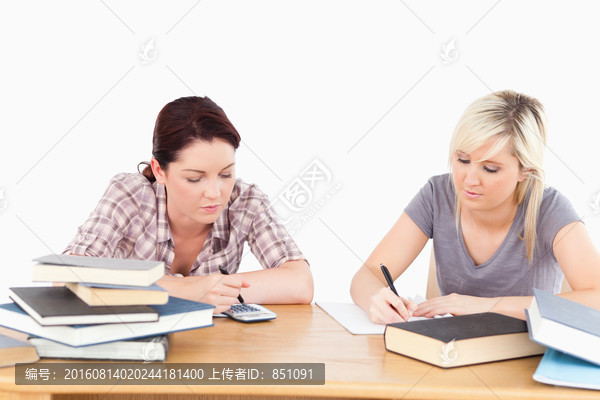 在餐桌上学习的两个女学生