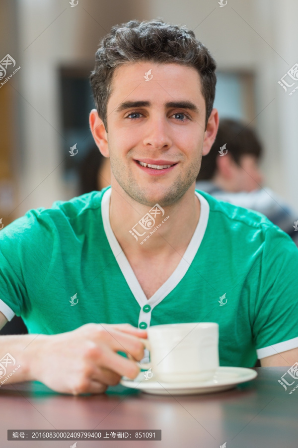 男子坐着喝着一杯咖啡