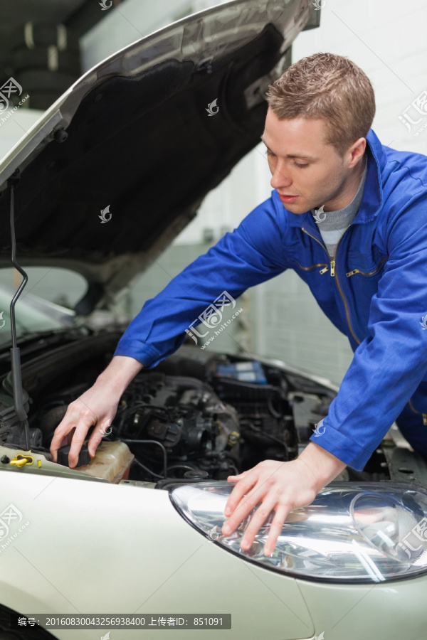 男性技工检查汽车发动机机油
