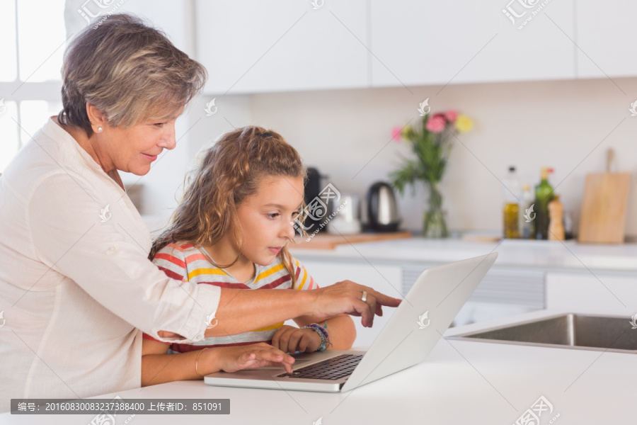 老妇人和小女孩一起看电脑