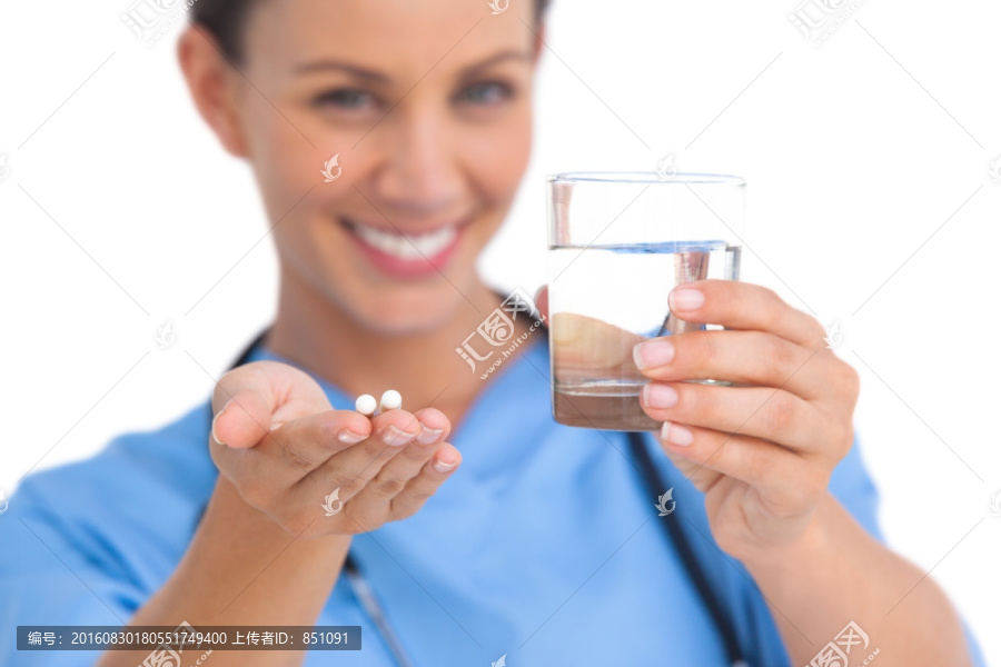 外科医生拿着药片和一杯水