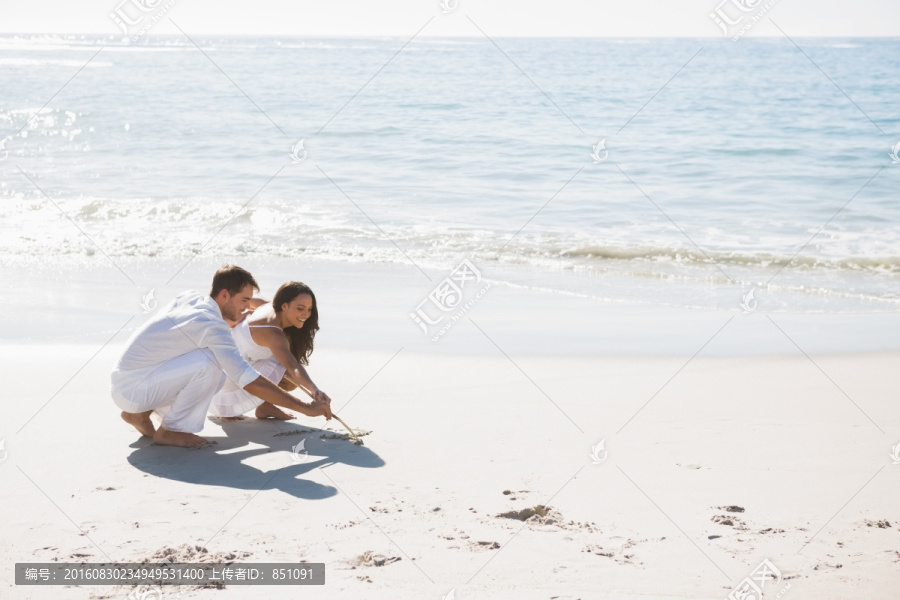 在沙滩上画画的情侣