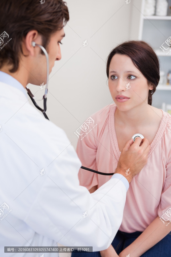 年轻医生检测病人的心脏跳动