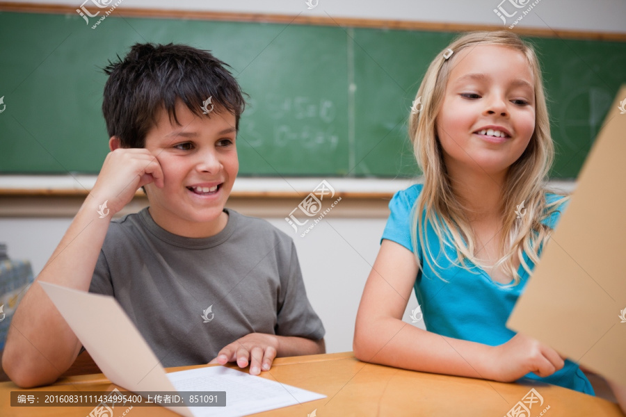 微笑的孩子在教室里看书