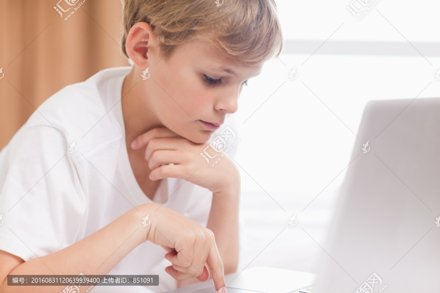 男孩在卧室里使用笔记本电脑