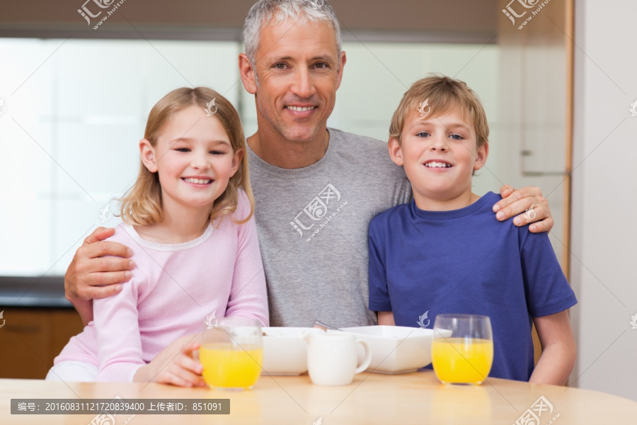 在早餐时父亲抱着他的孩子们