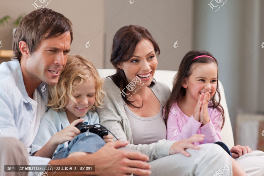 高兴的家人在客厅里玩电子游戏