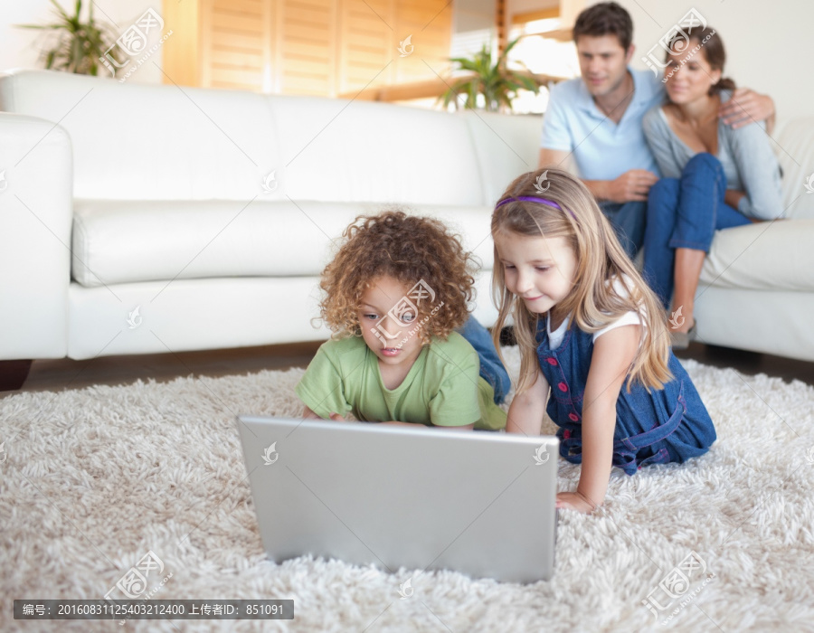 趴在地毯上用电脑的孩子