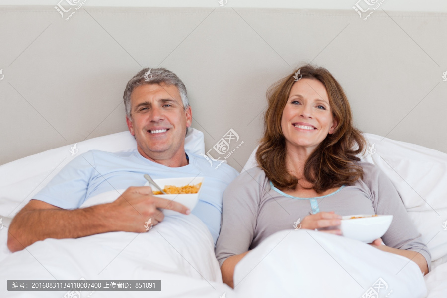 夫妇在床上吃饭