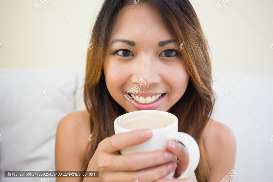 端着咖啡看着镜头的女人