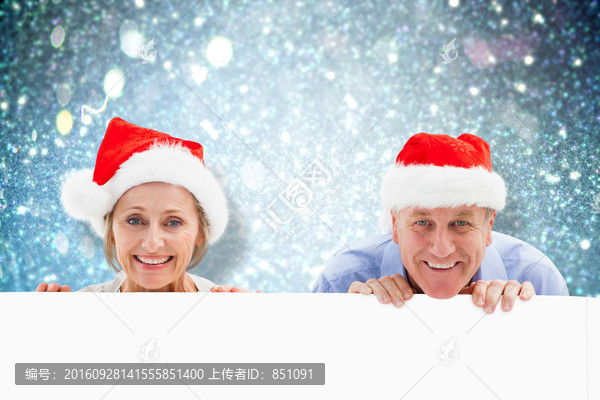 夫妇戴着圣诞帽微笑的复合形象