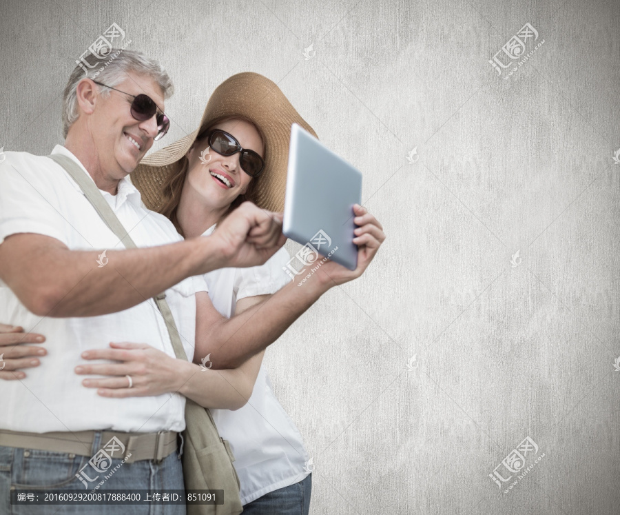 夫妇看着平板电脑的复合形象