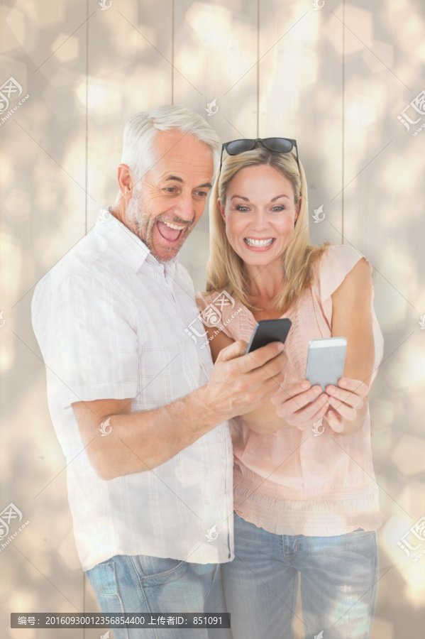 微笑着看着手机的夫妇