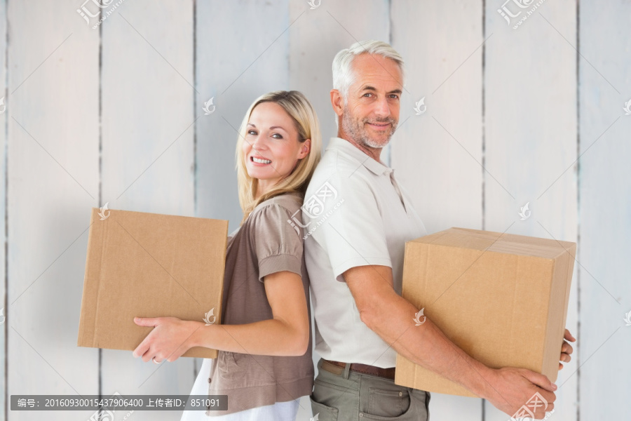 微笑着抱着纸箱的夫妇