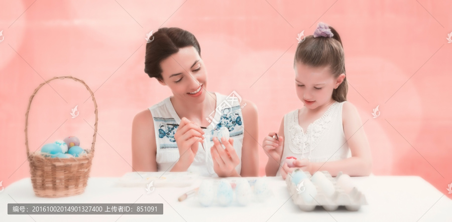 母亲和女儿画复活节鸡蛋