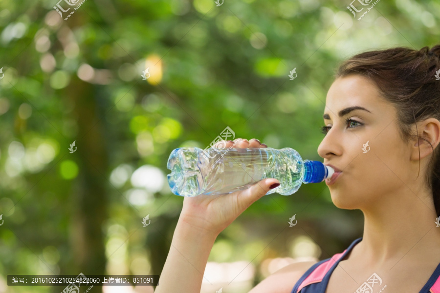 在户外喝水的女人