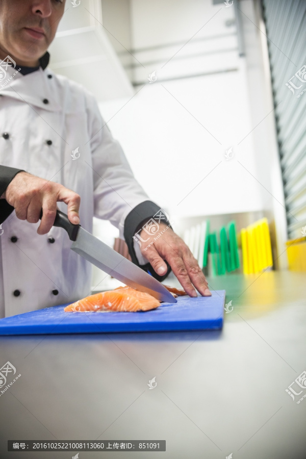 在在厨房里切三文鱼的男厨师