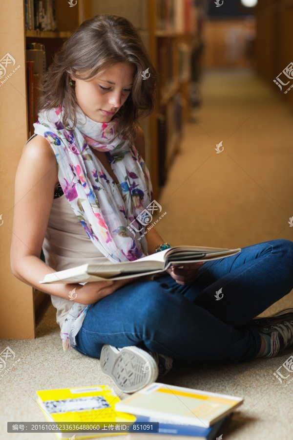 女学生在图书馆阅读一本书
