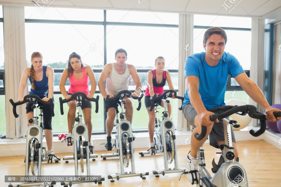 在健身房骑自行车的年轻人们
