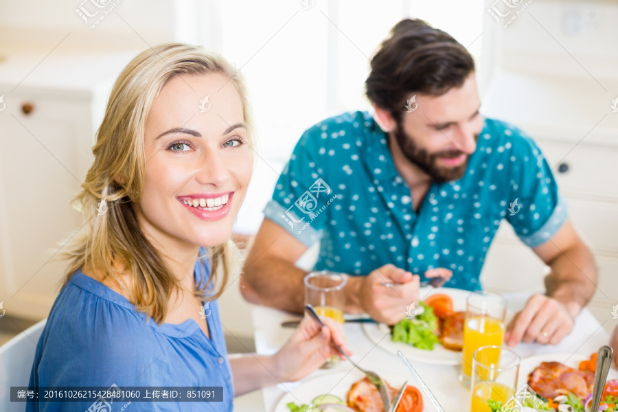 坐在餐桌前用餐的夫妇