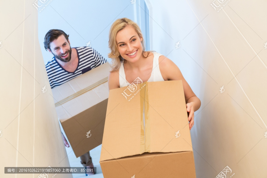 幸福的一对夫妇把纸箱搬进新房子