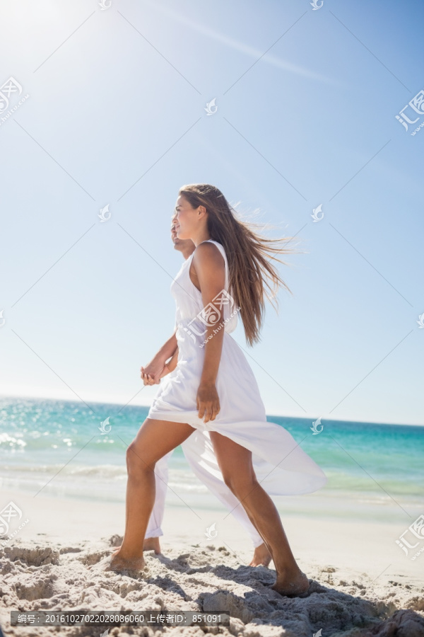 牵着手走在沙滩上的夫妇