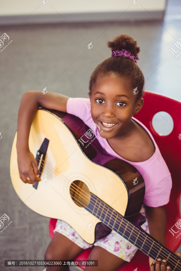 微笑着弹吉他的小学生