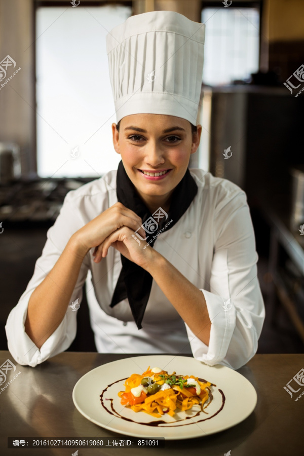 展示一盘菜肴的女厨师