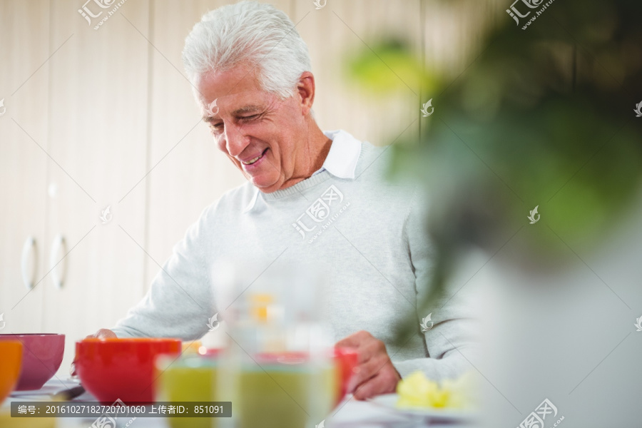 微笑着吃早餐的老年人