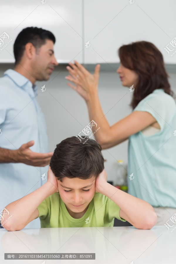 在吵架的父母和捂住耳朵的男孩