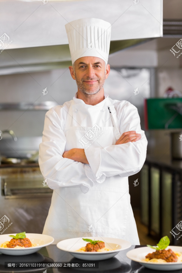 站在厨房里抱着双臂的男厨师