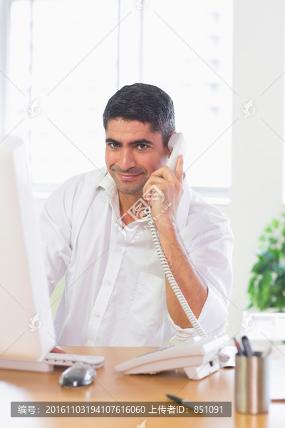 看着电脑打电话的商务男人