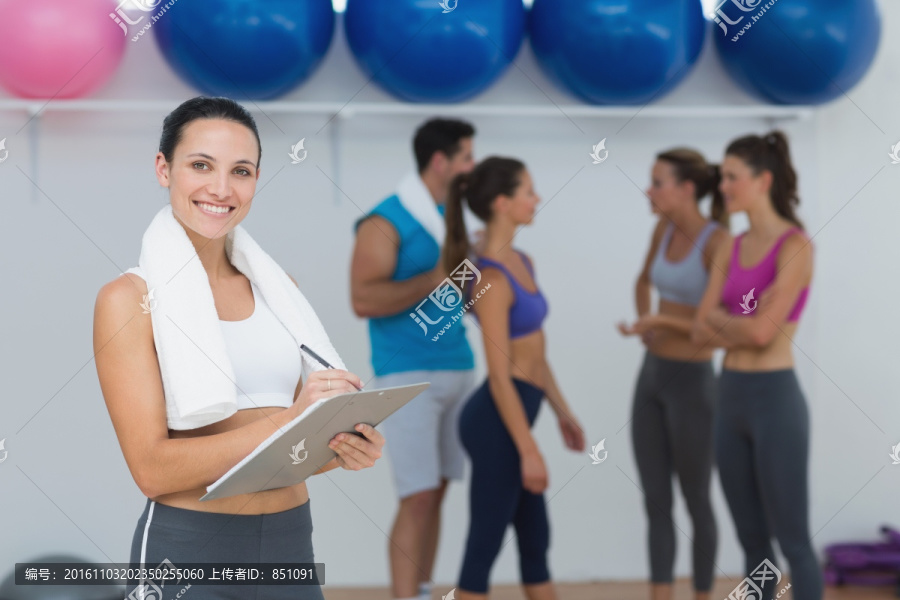 在健身房里写健身计划的女教练